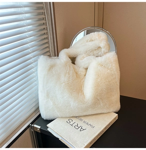 Détail du cabas en fausse fourrure crème montrant la texture douce dans un décor chic