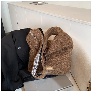 Gros plan du sac cabas marron en polaire avec doublure à carreaux et étiquette
