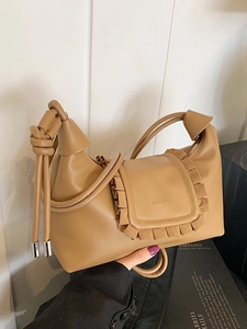 Chic caramel brown leather handbag with ruched flap and knotted strap detail