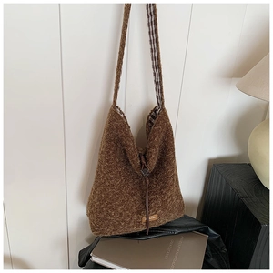 Gros plan du sac cabas en peluche marron montrant la texture et la doublure à carreaux