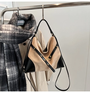 Detail of khaki suede and black leather patchwork tote bag with gold metal hardware