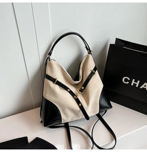 Close-up of contrast cream and black leather handbag with gold metal clasp details
