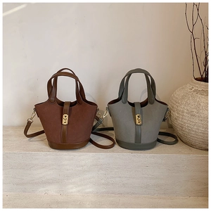 Detail of vintage bucket bags in brown and grey-green with gold buckle and straps