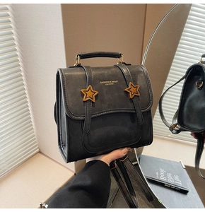 Detail of black vintage leather backpack with golden star metal buckles and top handle