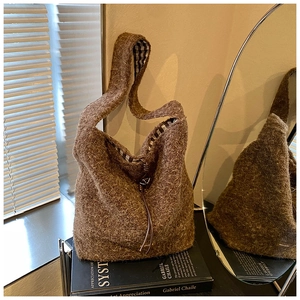 Détail du cabas en laine marron avec doublure à carreaux et cordon en cuir