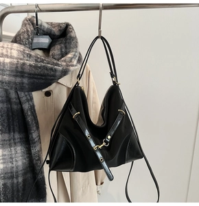 Detail of hobo bag showing waterproof nylon texture and leather trim on a hanger
