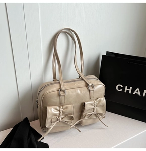 Detail view of beige retro Boston bag featuring bow pleats and silver metal hardware