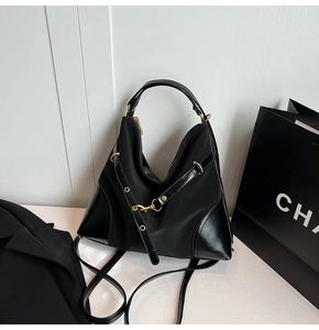 Detail of black Hobo bag with gold hardware and leather trim in professional office setting