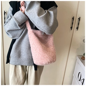 Gros plan sur le sac fourre-tout rose pelucheux montrant la texture douce et l'étiquette