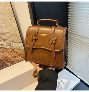 Detail of caramel brown leather backpack with star buckles and fashion text engraving