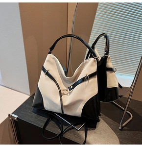 Detail of two-tone crossbody bag with beige suede body and black glossy accents