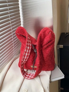 Sac cabas en laine rouge avec doublure vichy et étiquette cuir dans un décor d'intérieur