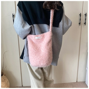 Détail du sac cabas en maille rose pelucheuse avec étiquette Have a Nice Day sur un mannequin