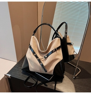 Detail of minimalist khaki tote with black leather trim and elegant mirror reflection
