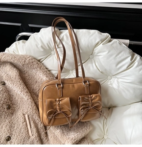 Brown vintage faux leather shoulder bag featuring bow-tie pockets and pleated details