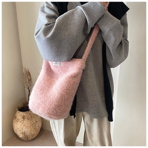 Détail de la texture du sac seau en peluche rose et de l'étiquette 'Have a nice day'
