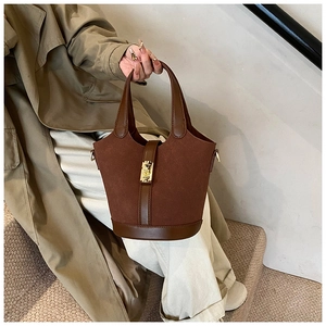 Detail showing high-quality dark brown suede and leather texture with golden hardware