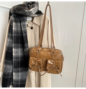 Detail of vintage brown glossy handbag with bow pockets and thin straps for autumn styling