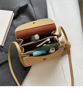 Detail of the yellow leather crossbody bag internal compartments and storage space