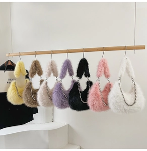 Row of seven colorful faux fur crescent bags with beaded chains on a wooden hanger