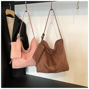 Detail of matte suede tote bags in dusty rose and brown with matching pouches