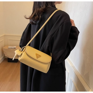 Detail of light yellow lychee grain leather handbag with metal logo and horse charm