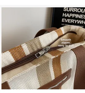 Detail of smooth metal zipper closure and canvas texture on striped tote bag