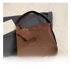 Detail view of brown frosted suede tote bag with matching zippered inner pouch and leather strap