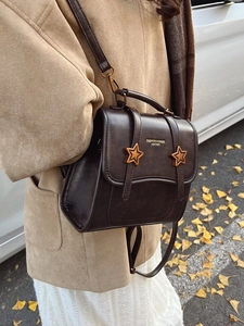 Retro dark brown leather square backpack with star buckles shown in an outdoor setting