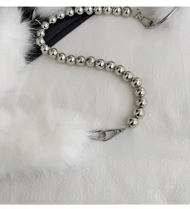 Detail of silver beaded metal chain strap with lobster clasp and white faux fur trim