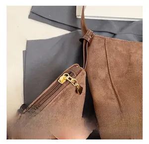 Detail of the golden metal zipper and frosted suede texture on the brown tote bag