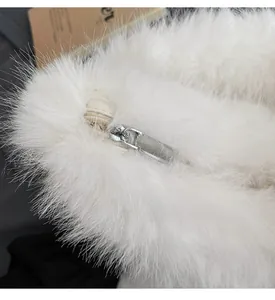 Close-up of smooth silver metal zipper on white long-hair plush handbag material