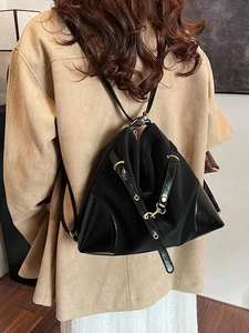 Versatile black nylon and leather backpack with gold hardware in a chic slouchy design