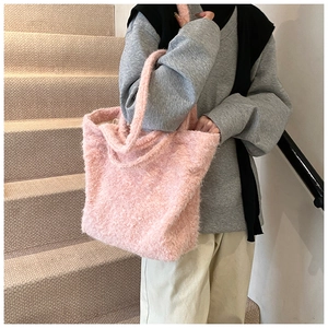 Détail du sac cabas en fausse fourrure rose montrant la texture douce et les poignées
