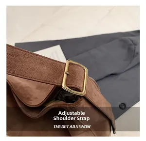 Close-up of adjustable shoulder strap with golden buckle on brown matte tote bag