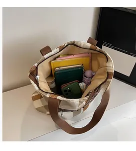 Spacious interior of striped canvas tote bag showing storage for books and tablets