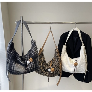 Close-up of leopard print and plaid plush hobo bags with unique baseball themed pendants