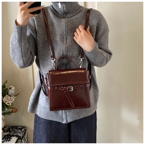 Detail der dunkelburgunderroten Vintage-Ledertasche mit Schnalle und Schultergurt