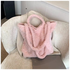 Détail du sac cabas en peluche rose montrant la texture douce et les anses rondes