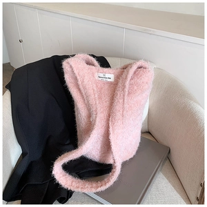 Détail du cabas en peluche rose avec une étiquette tissée représentant un chat