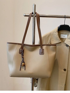 Grande borsa shopper kaki con finiture a contrasto marroni ed elegante ciondolo a campana