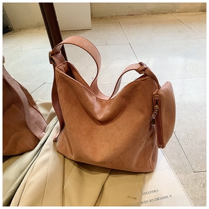 Detail of peach suede tote bag with matching zipper pouch and metal strap buckle
