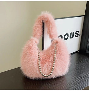 Close-up of soft pink plush handbag featuring decorative silver metallic beaded chain