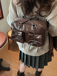 Retro dark brown glossy PU leather Boston bag with bow pockets shown on a model
