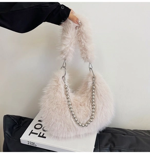 Close-up of plush faux fur handbag with silver beaded chain and cozy winter texture