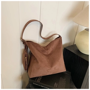 Detail of a large brown suede hobo tote bag featuring a removable matching coin purse charm