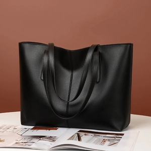 Detalle de bolso tote de cuero PU negro con una elegante costura vertical central