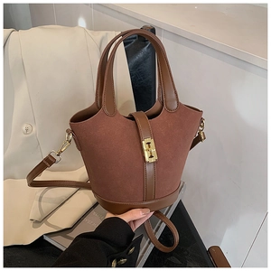 Close-up of vintage brown suede bucket bag with gold twist lock and leather handle