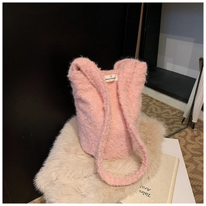 Gros plan d'un sac cabas rose en peluche avec texture douce et étiquette tissée