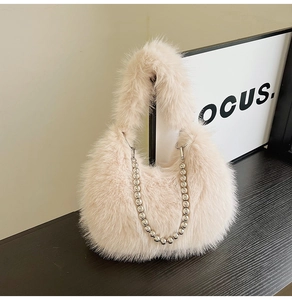 Detailed macro of plush faux fur texture and silver beaded chain on beige handbag